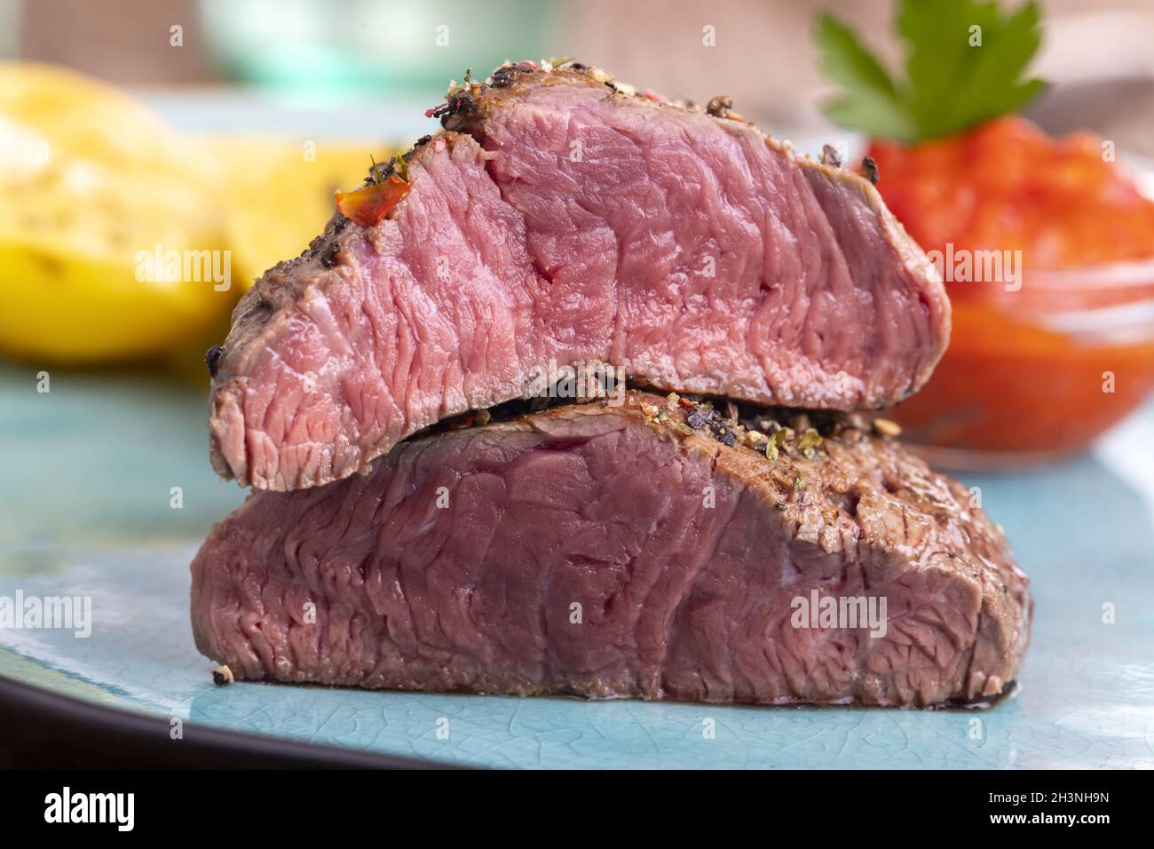 Pepare la bistecca su un piatto blu Foto Stock