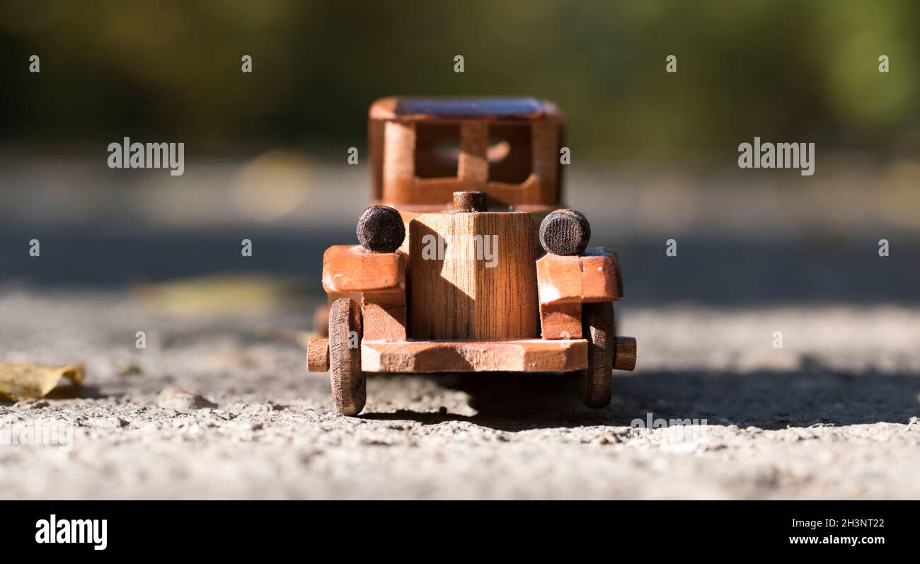 vecchia auto giocattolo in legno retrò sulla strada in autunno foresta Foto Stock