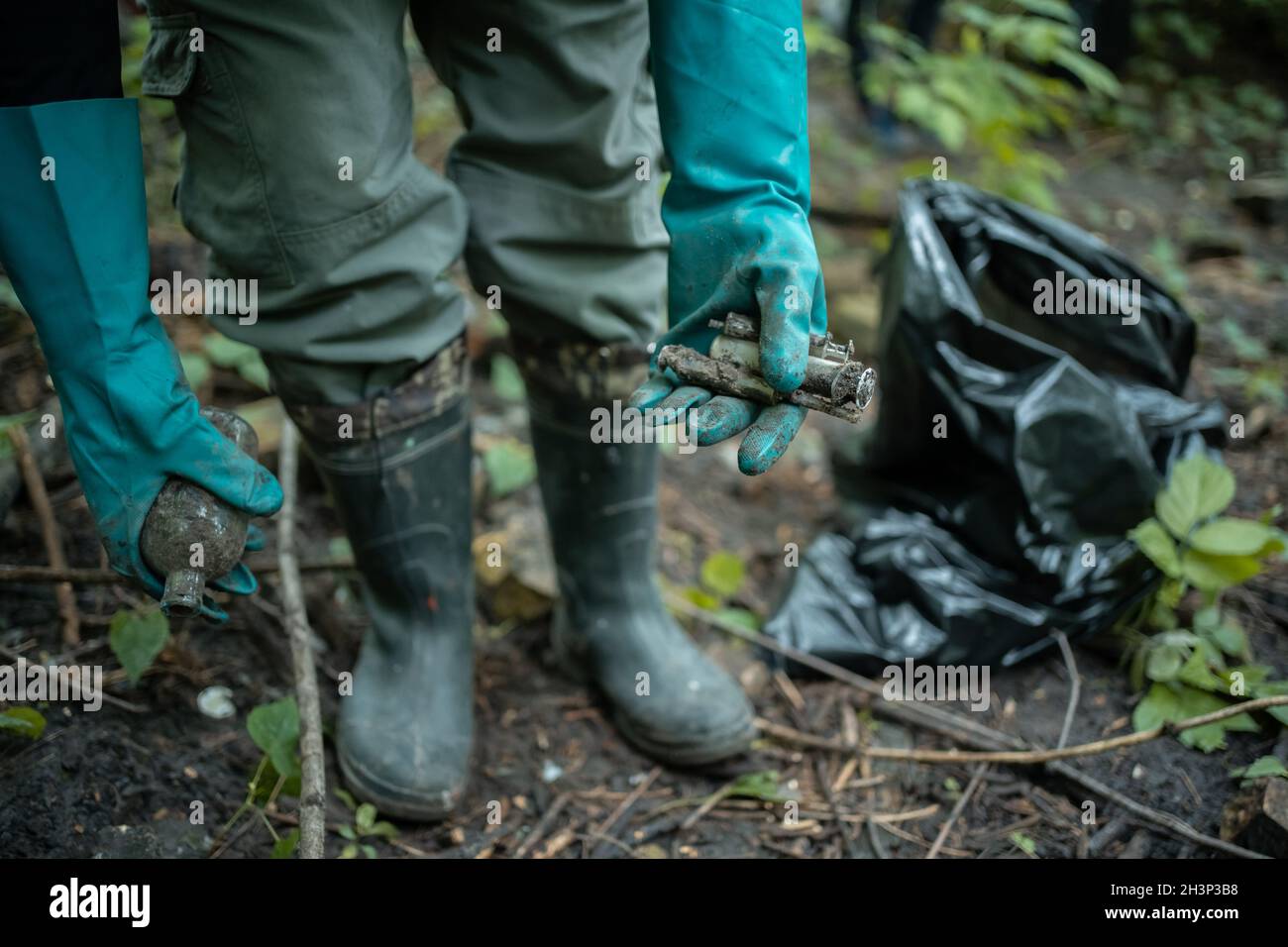 il pulitore volontario sta pulendo il parco e sta in piedi da un mazzo di sacchetto della spazzatura Foto Stock
