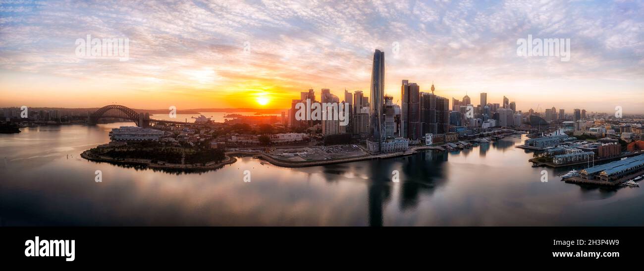 L'alba panoramica sullo skyline del CBD di Sydney si riflette nelle acque calme del porto di Sydney e del porto di Darling - panorama aereo. Foto Stock