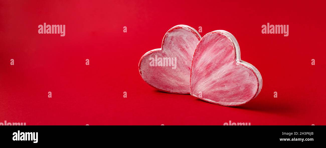 Due cuori valentini fatti di carta mache su sfondo rosso. Simbolo d'amore e di festa San Valentino. Foto Stock