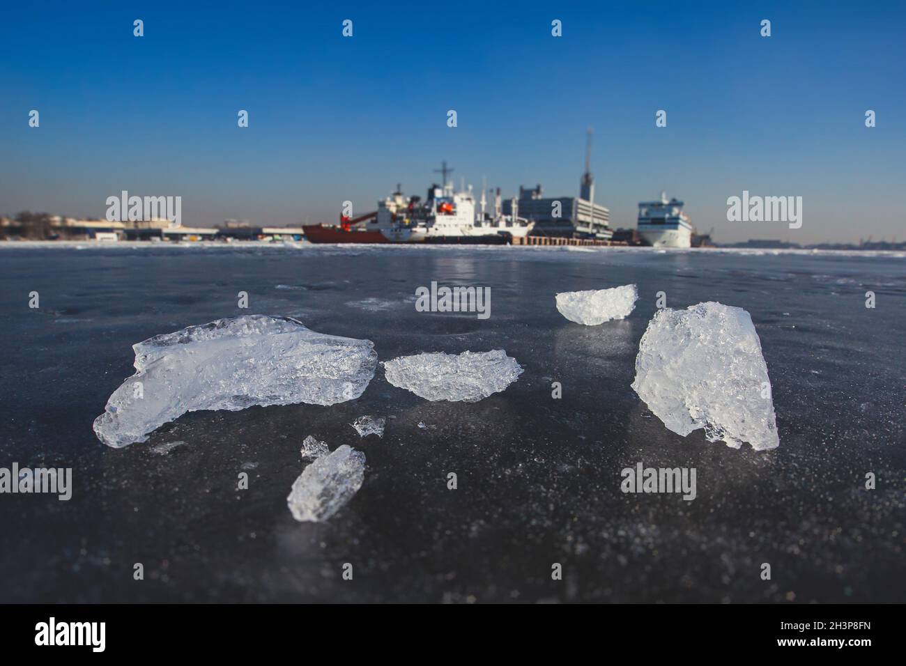 Enormi navi diverse intrappolate nel ghiaccio cerca di rompere e lasciare la baia tra i ghiacciai, rompighiaccio e nave portaerei, cielo blu d'inverno Foto Stock