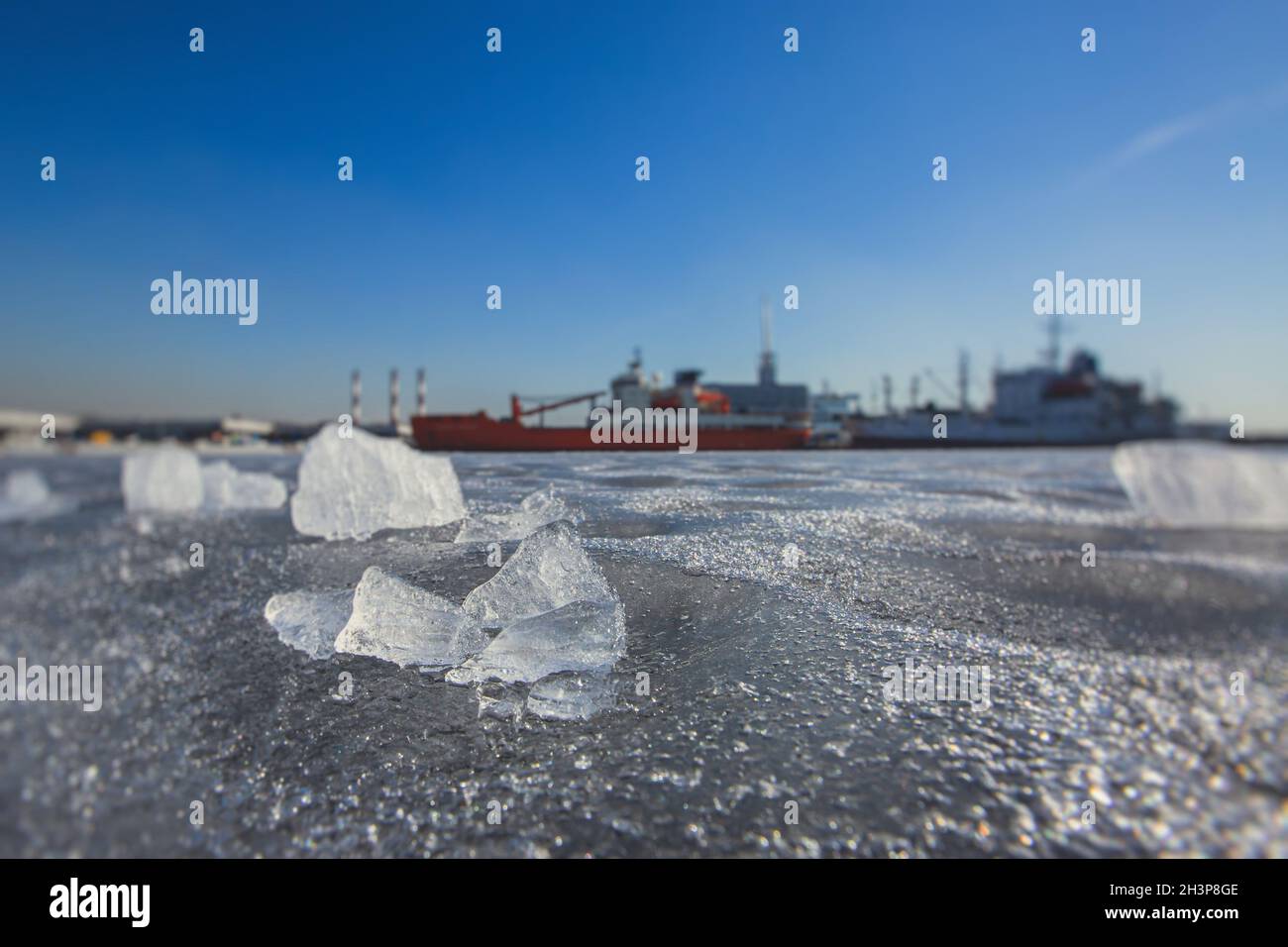 Enormi navi diverse intrappolate nel ghiaccio cerca di rompere e lasciare la baia tra i ghiacciai, rompighiaccio e nave portaerei, cielo blu d'inverno Foto Stock