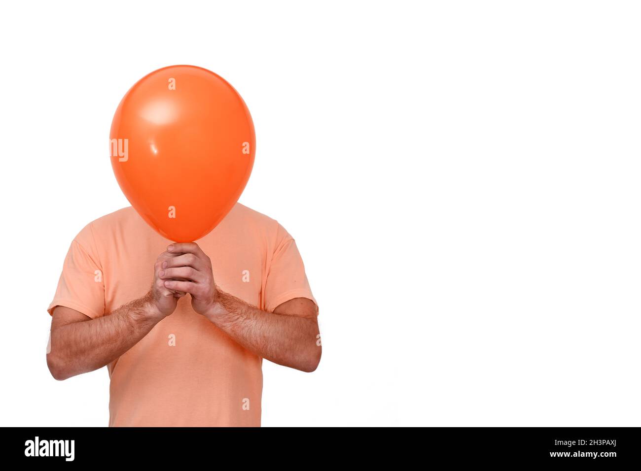 Un uomo tiene un pallone davanti alla testa. Il palloncino è come una maschera. Foto Stock