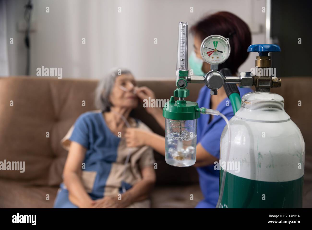 Donna anziana che indossa la canula nasale dell'ossigeno a casa. Foto Stock