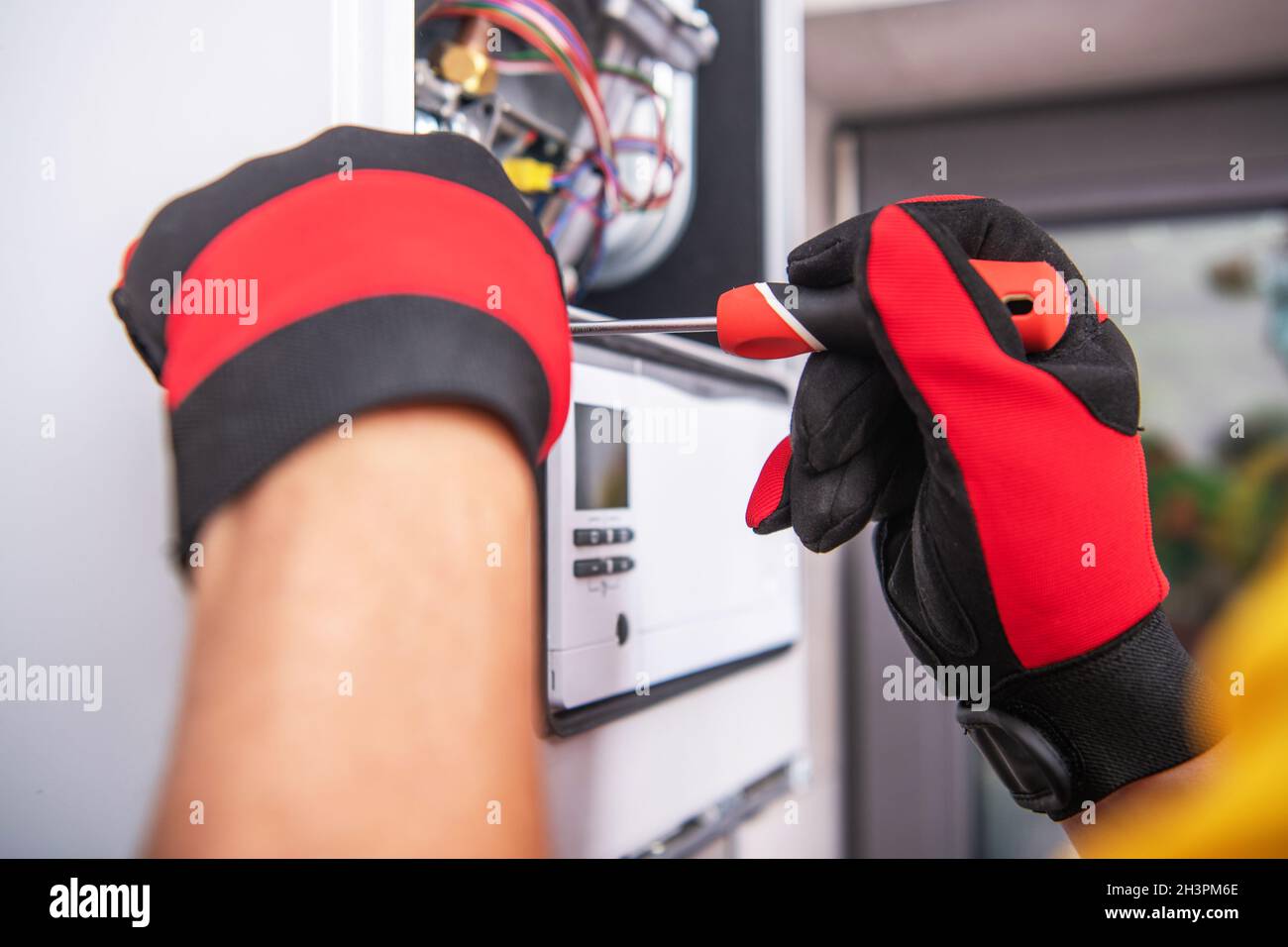 Dispositivi caucasici il tecnico HVAC ripara il dispositivo riscaldatore a gas rotto. Chiudi foto. Tema industriale. Foto Stock