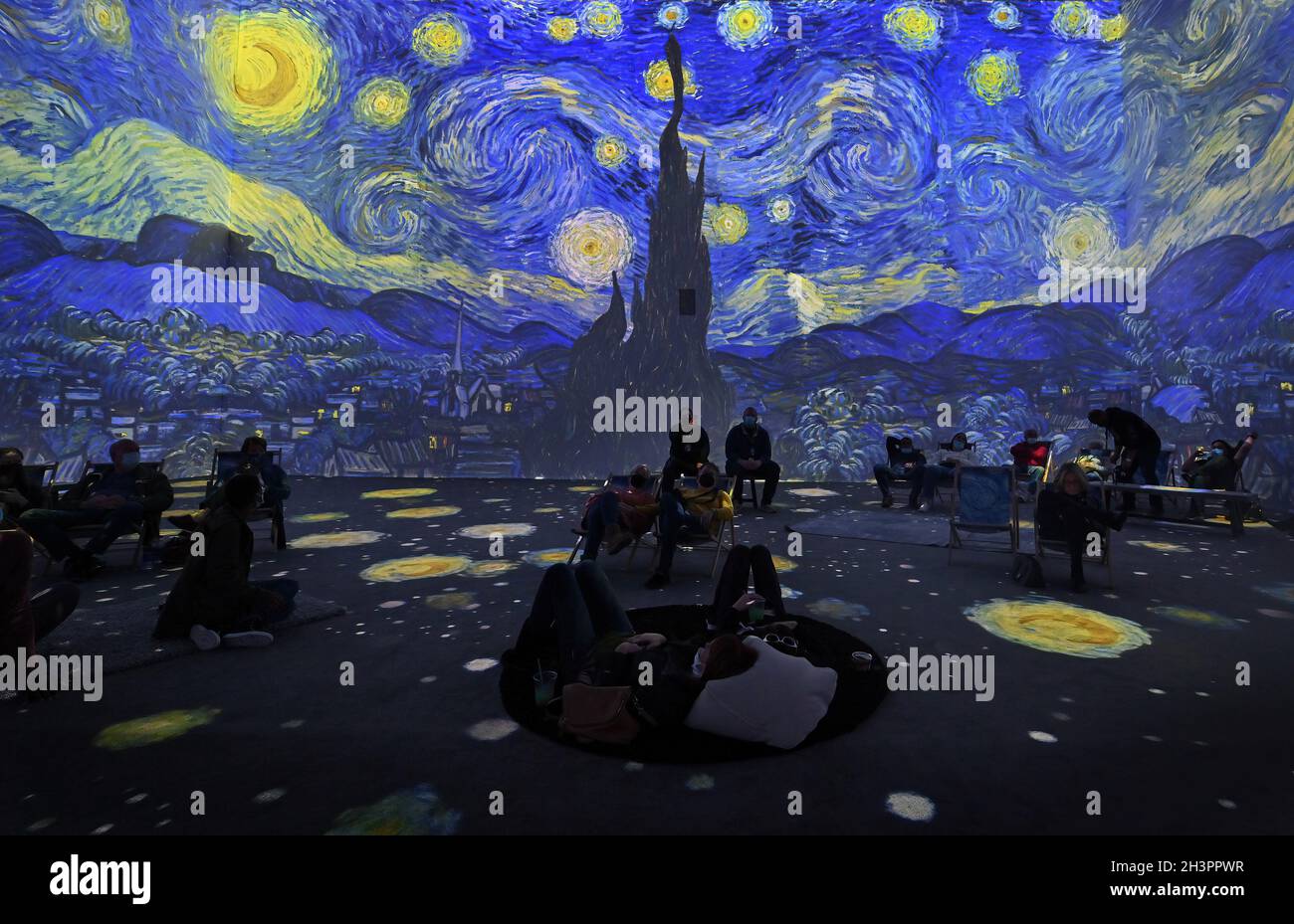 Upper Darby, Stati Uniti. 23 ottobre 2021. I Museum-Goers osservano una proiezione della Notte stellata di Van Gogh durante lo spettacolo. Van Gogh l'esperienza immersiva è uno spettacolo di mappatura delle proiezioni in una sala a due piani nel Tower Theatre. Lo spettacolo mostra una vista a 360 gradi di alcuni dei lavori più popolari di Van Gogh, la sala ha cuscini, panchine e sedie per i musei-amanti di rilassarsi mentre si guarda lo spettacolo. Credit: SOPA Images Limited/Alamy Live News Foto Stock