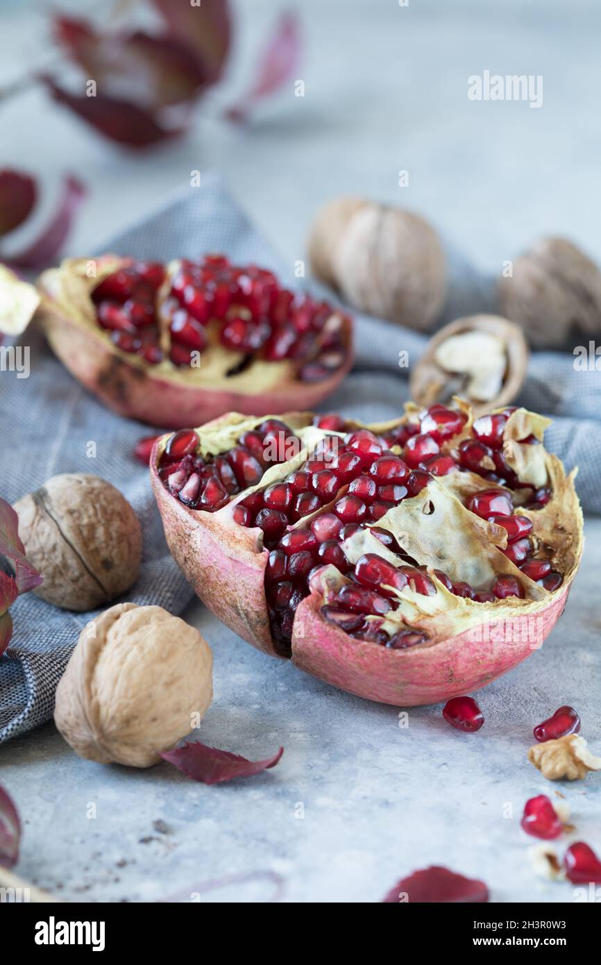 Diversi frutti di melograno maturi e noci. Il melograno è ricco di potassio, magnesio, calcio, ferro e manganese. Foto Stock