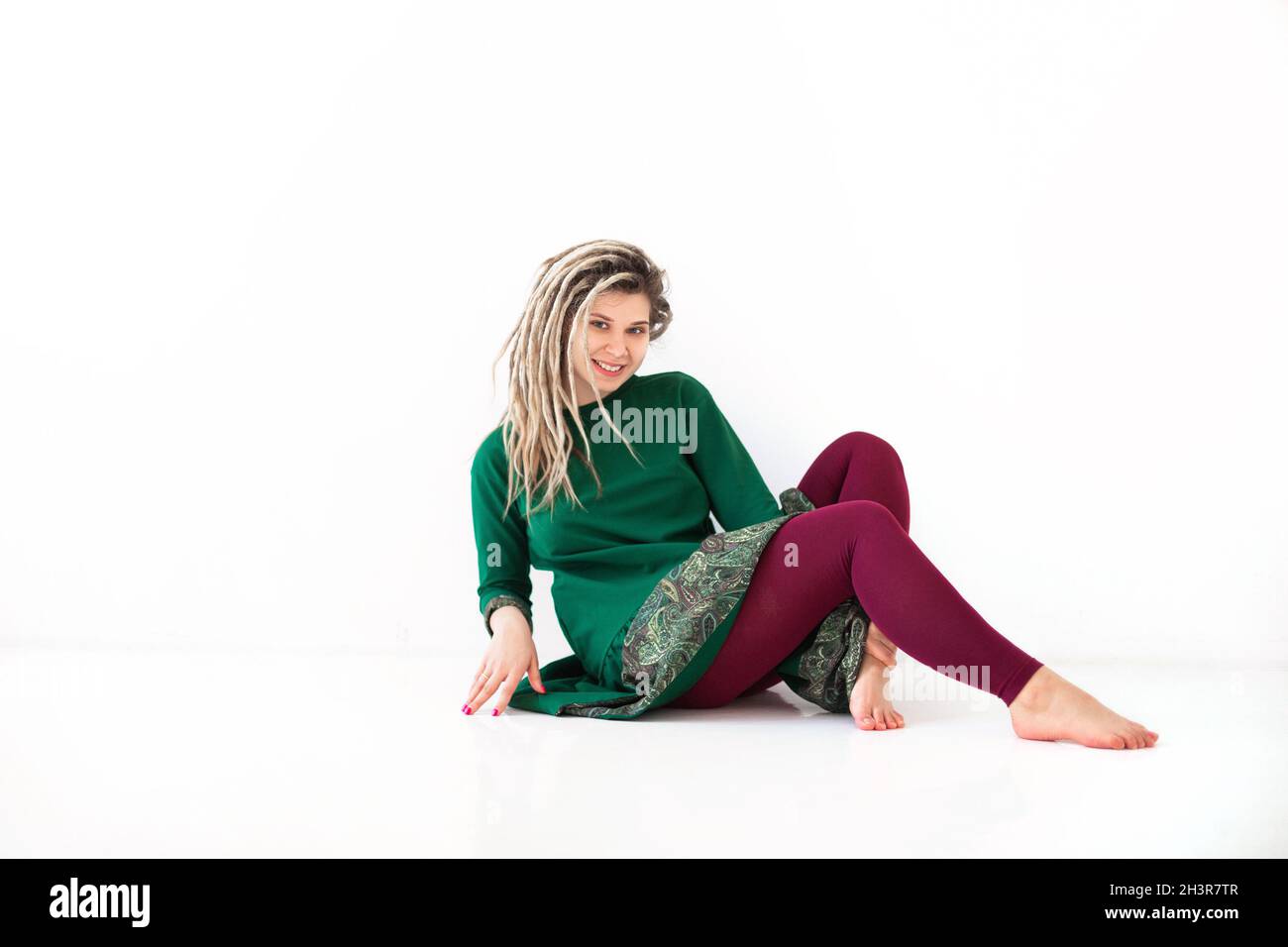 Donna felice che scuote i dreadlock e sorride Foto Stock