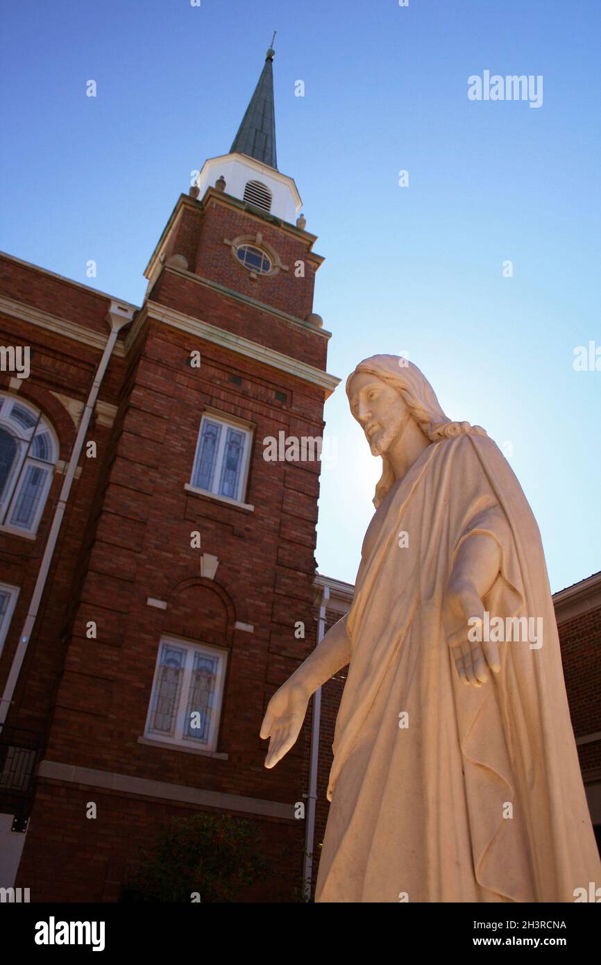 Statua di Gesù e Chiesa Steeple con il sole Foto Stock