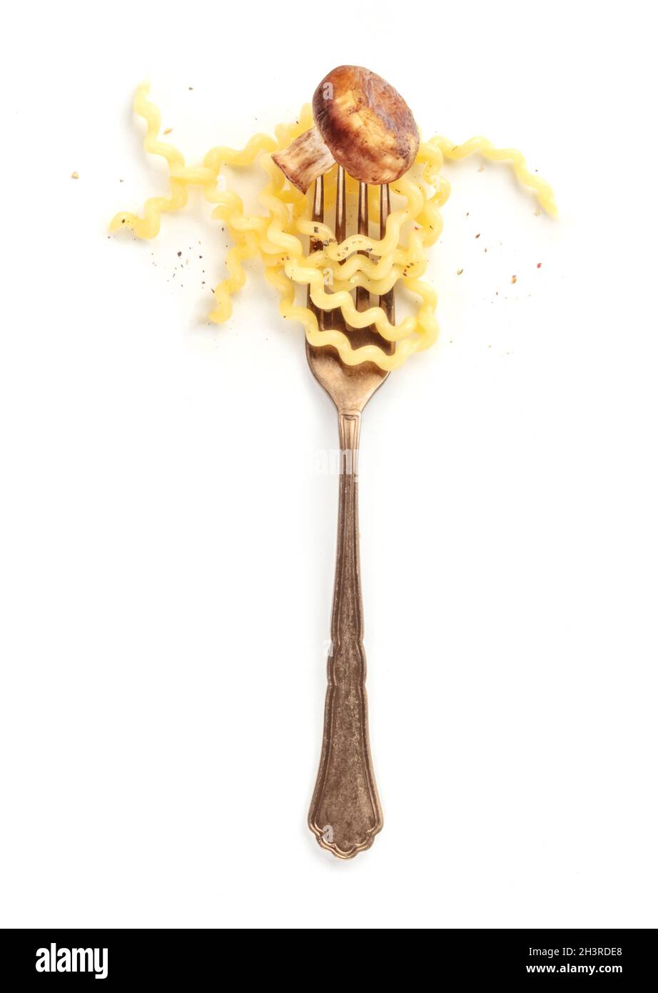 Design della pasta. Una forchetta con fusilli e un fungo fritto Foto Stock