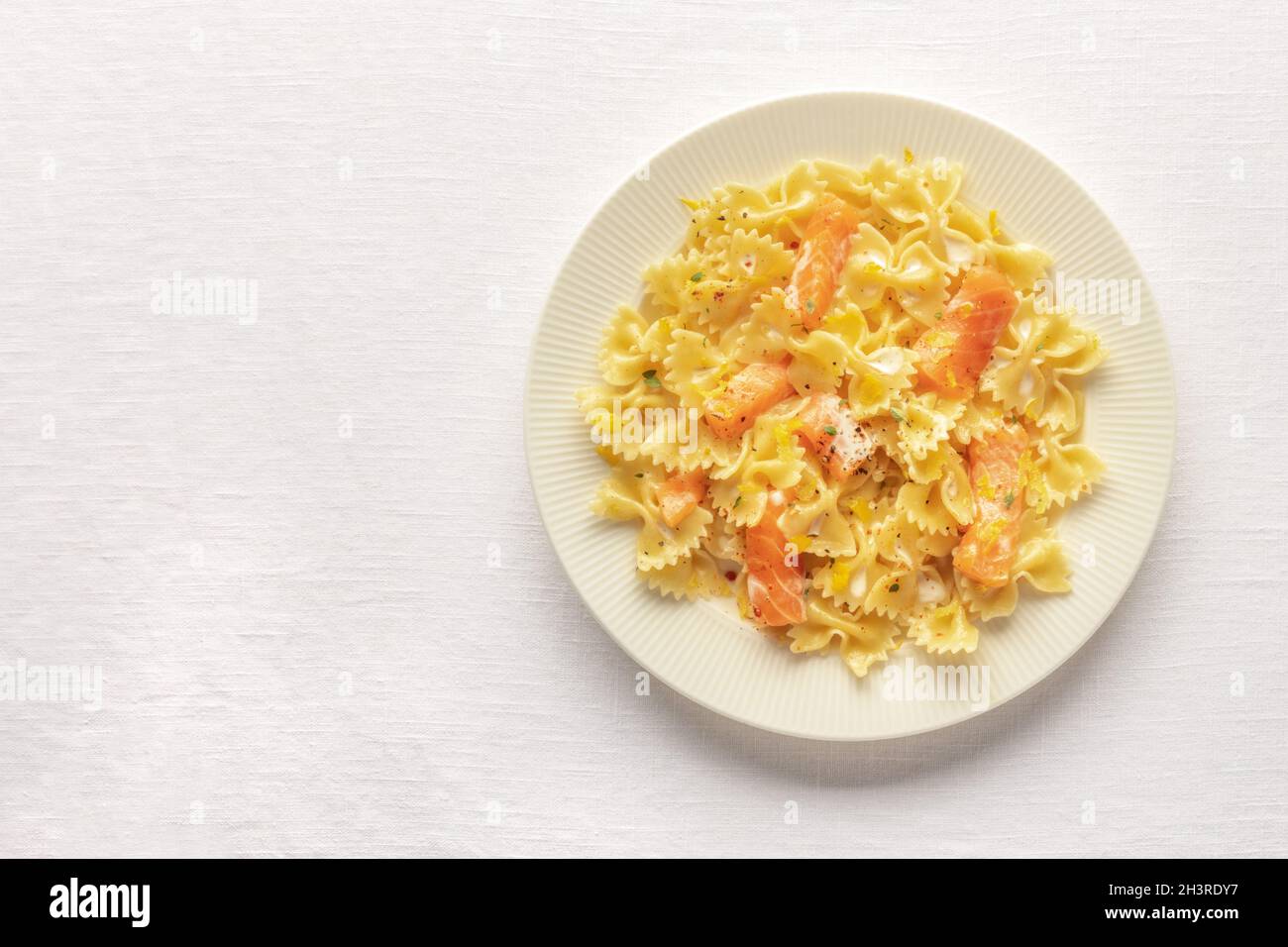 Salmone affumicato con farfalle. Pasta con salmone e salsa di panna Foto Stock