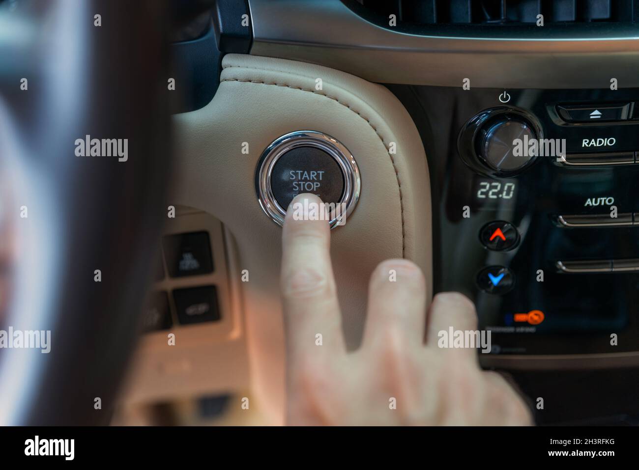 Il dito dell'uomo che preme il pulsante START. Utilizzare il pulsante per avviare e arrestare il motore. L'autista è pronto per il viaggio Foto Stock