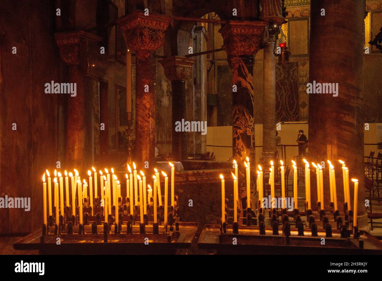 Le persone bruciano candele in basilica in piazza San Marco a Venezia Foto Stock