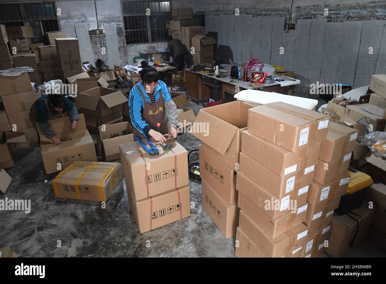 Lingchuan, Cina. 29 ottobre 2021. (211030) -- LINGCHUAN, 30 ottobre 2021 (Xinhua) -- i membri del personale imballano i ventilatori circolari di bambù di Guilin ad un'azienda locale nella città di Dingjiang di Guilin, regione autonoma di Guangxi Zhuang della Cina del sud, 29 ottobre 2021. Fare di un tale ventilatore non è un compito semplice, gli artigiani tagliano il bambù ammollato in dozzine di strisce per fare il telaio del ventilatore, incollano la superficie con carta di Xuan, stoffa di cotone e seta, infine fanno il ventilatore circolare attraverso taglio e bordo che avvolge, e una buona pittura e/o calligrafia la rende un elemento popolare nel mercato culturale. (Xinhua/Lu Boan) Cre Foto Stock