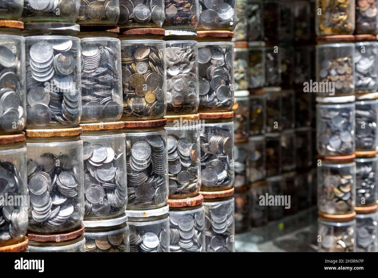 Monete poste in vasetti di vetro. Monete di molti paesi, fatte di metalli diversi. Numismatica è la raccolta di monete o banconote. Foto Stock