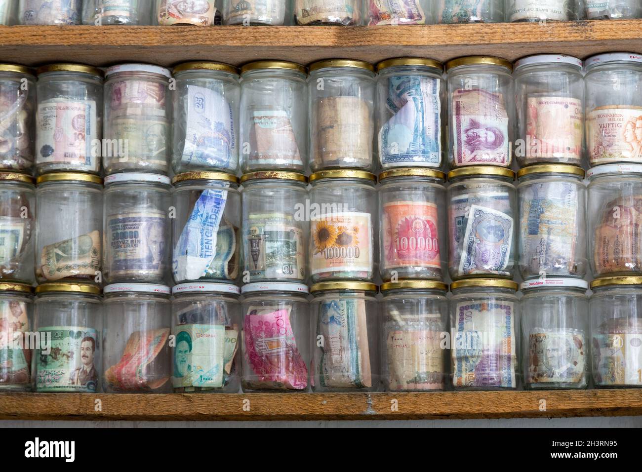 Valute mondiali attualmente in uso o obsolete. Banconote poste in vasetti di vetro. Numismatica è la raccolta di monete o banconote. Foto Stock