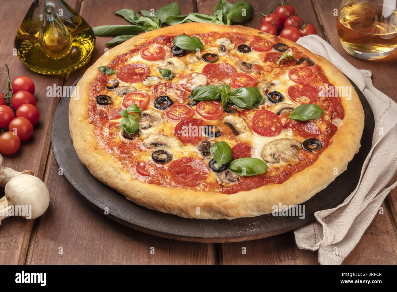 Pizza di peperoni su una panna di pizza, con vino bianco e ingredienti Foto Stock