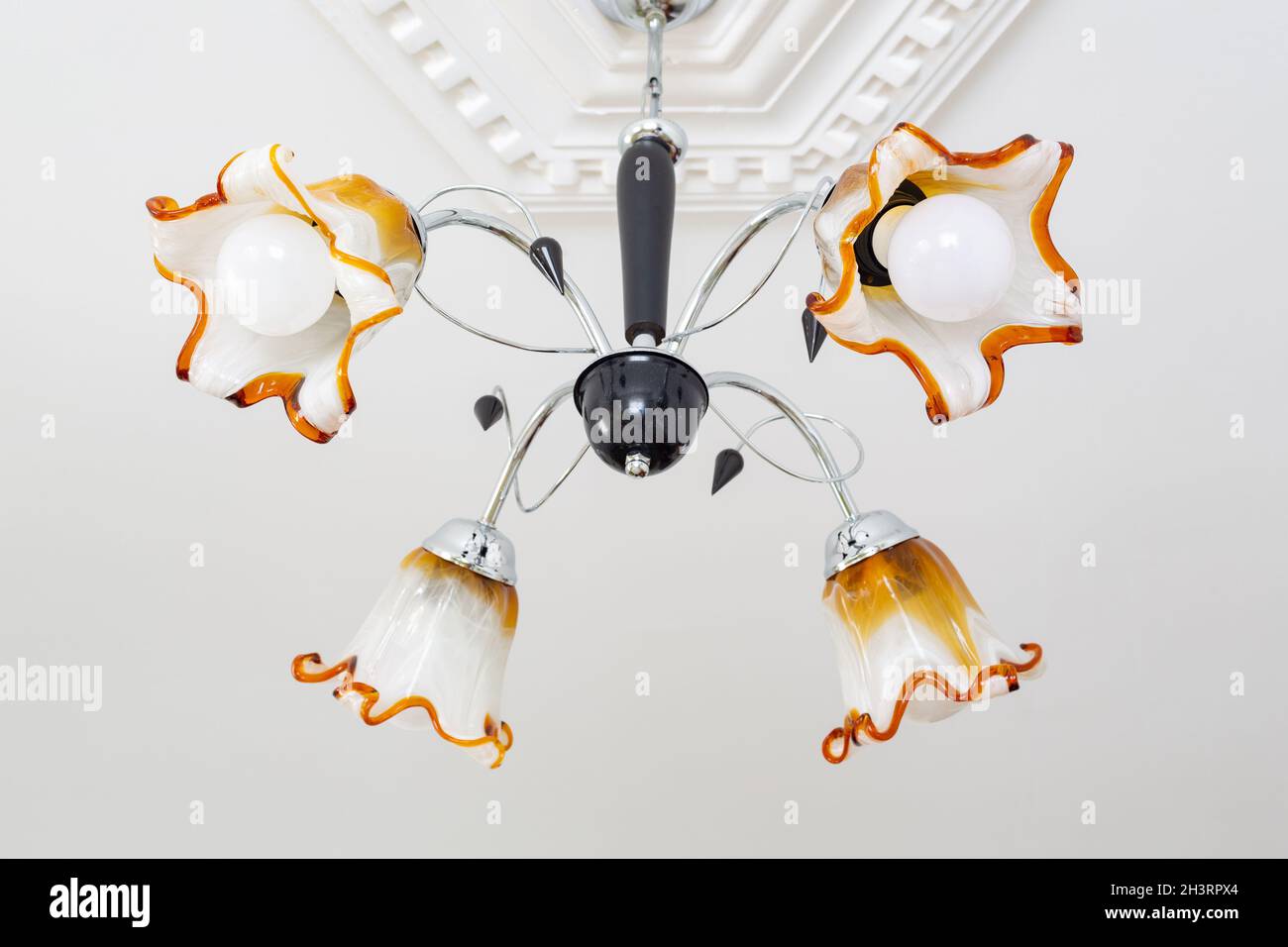 La lampada da soffitto a quattro bracci è realizzata in vetro a forma di fiore. Foto Stock