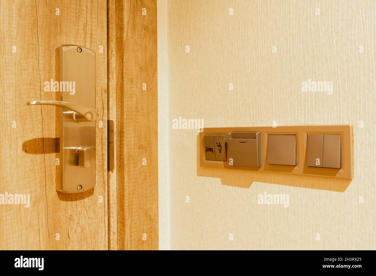 Maniglia e serratura interna della porta della camera d'hotel. Pulsanti elettrici, non disturbare e di pulizia sulla parete. Foto Stock
