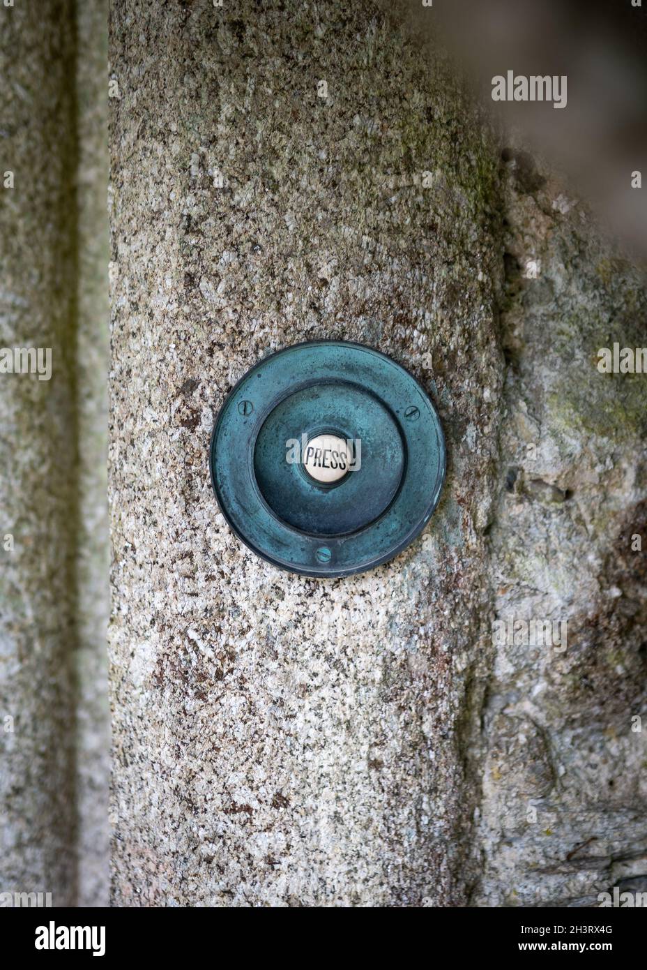 Vecchio campanello vintage porta posto in pietra porta. Grande metallo che circonda con la parola pressa scritta su di esso. Foto Stock