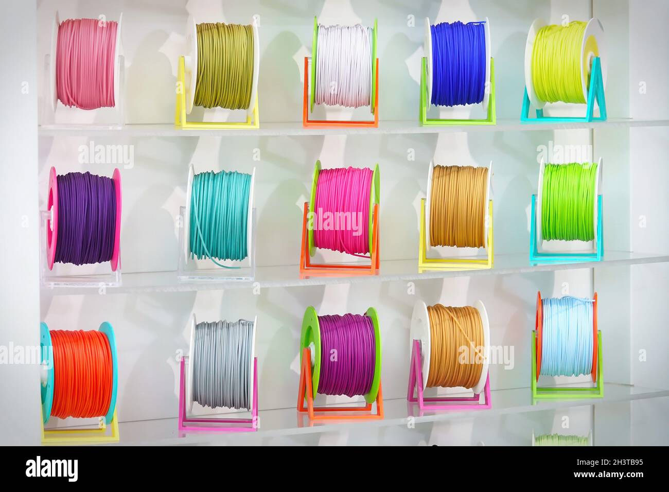 colorata ampia fila panoramica di bobine stampante 3d pla abs filamento materiale plastico isolato Foto Stock
