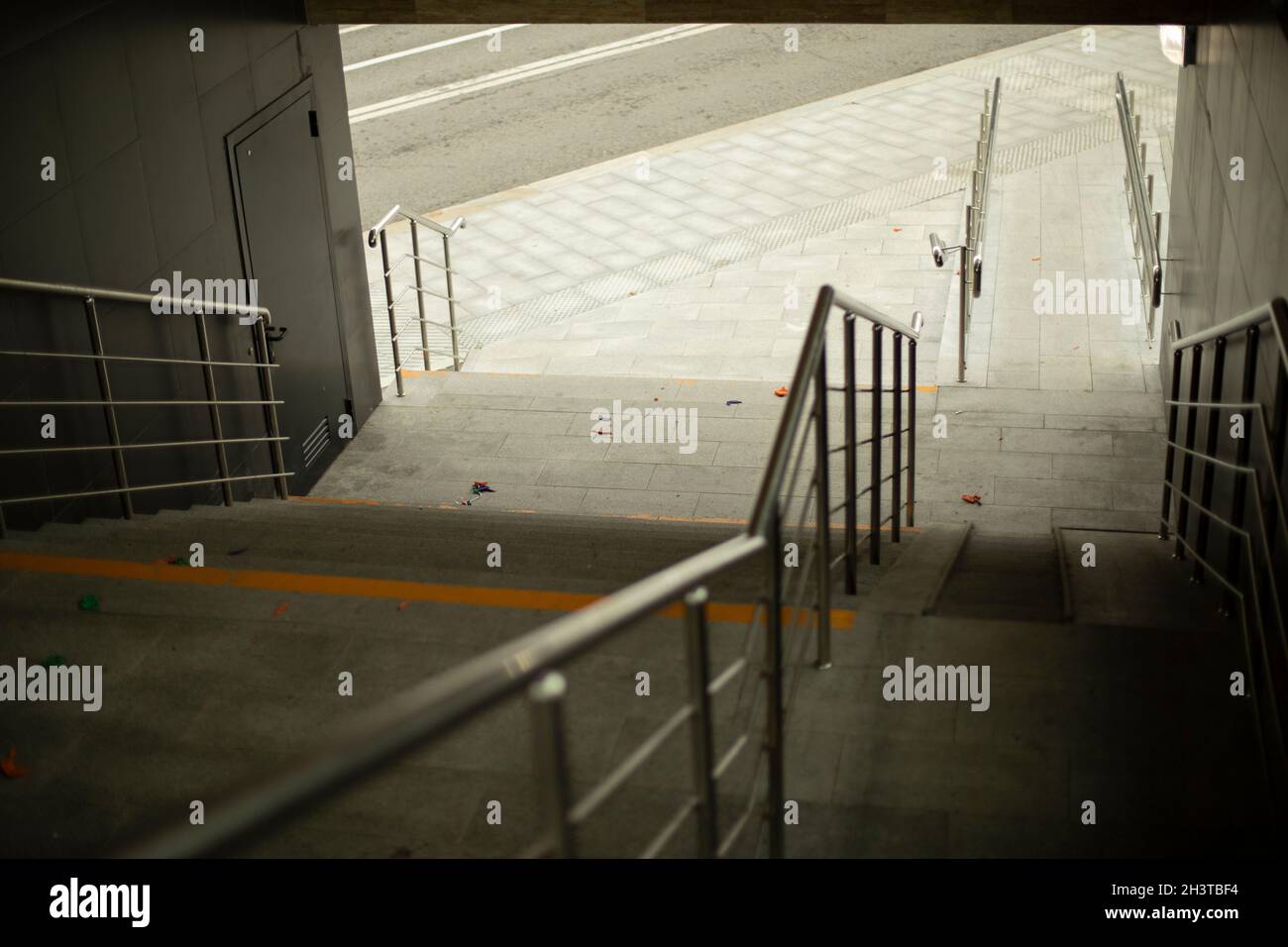 Corrimano in acciaio per il supporto durante la discesa dei gradini. Infrastrutture di trasporto urbano per pedoni. Foto Stock