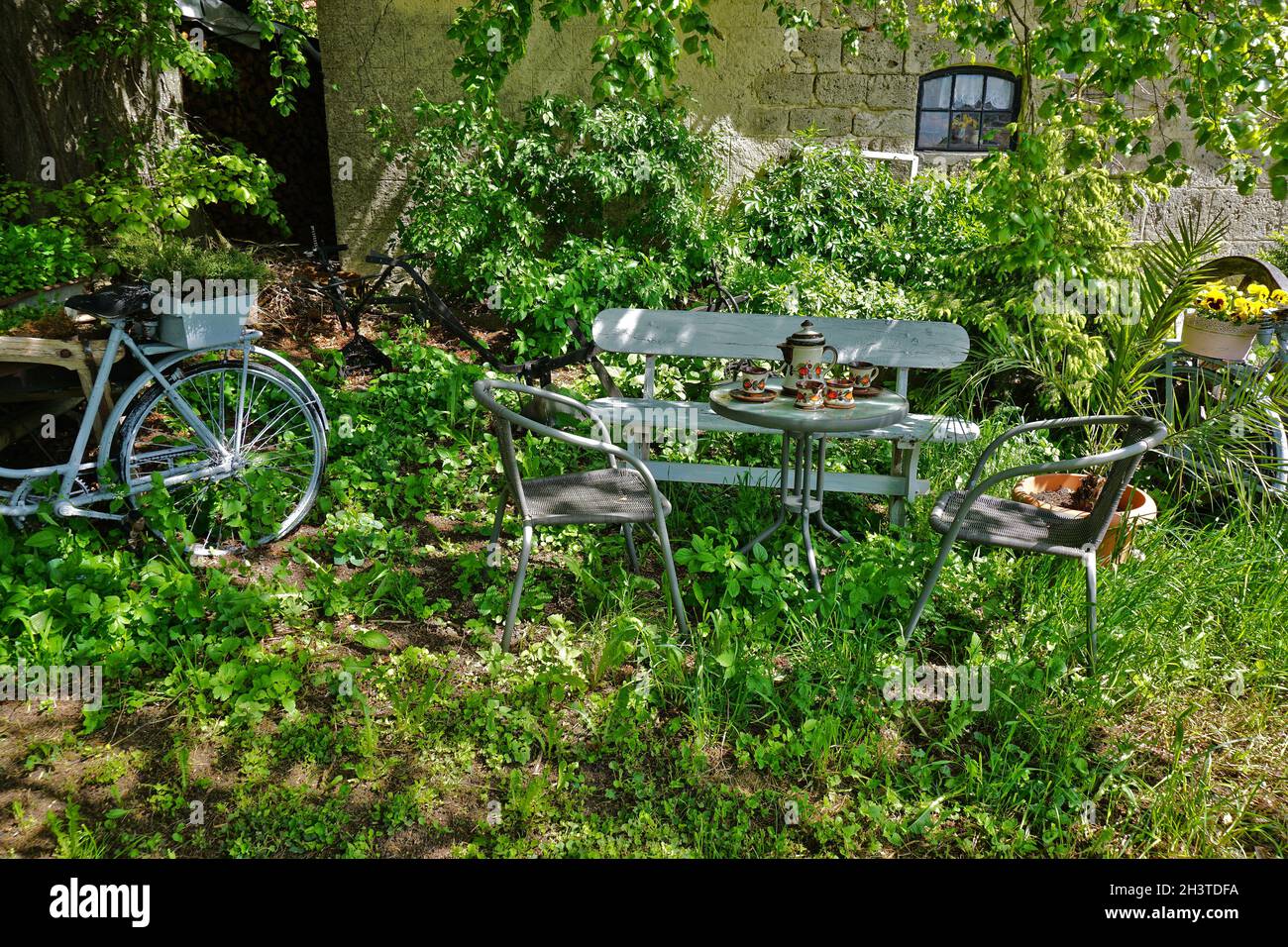 Panca da giardino, tavolo e sedie per rilassarsi Foto Stock