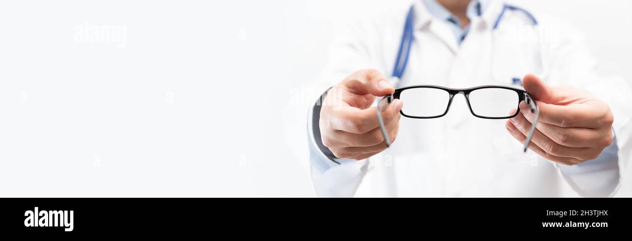 Medico oculare, oculista in clinica. L'optometro tiene gli occhiali da provare. Immagine spazio di copia banner Web Foto Stock