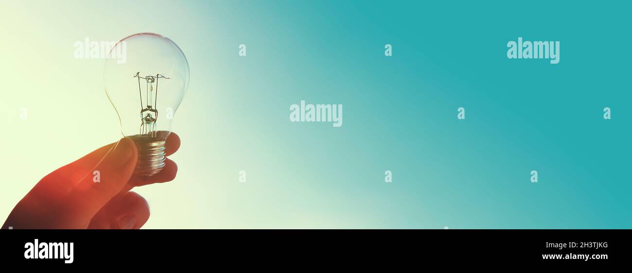 Concetto di crisi energetica globale. L'uomo tiene la lampadina in alto Foto Stock