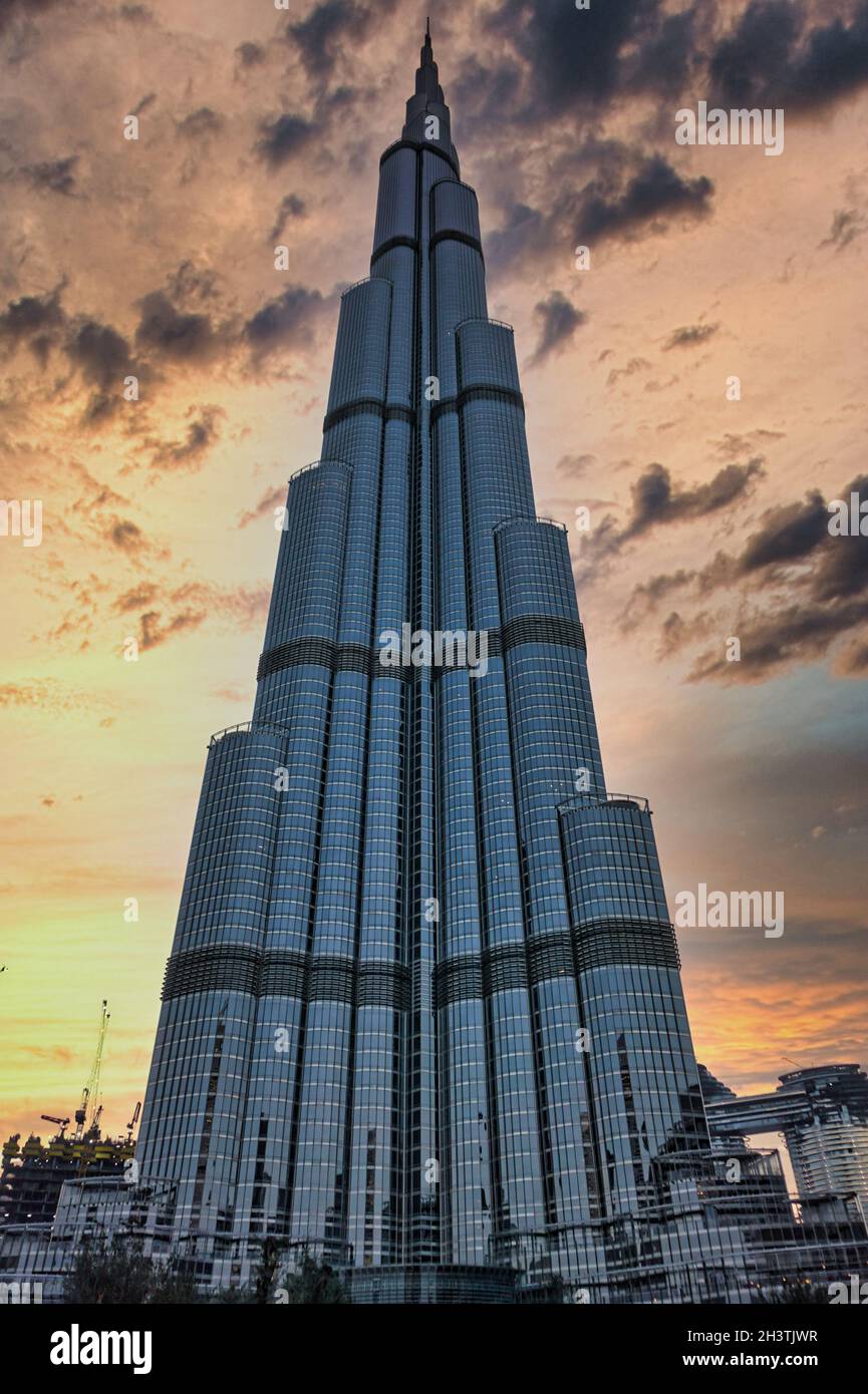 Inquadratura a basso angolo del famoso grattacielo Burj Khalifa di Dubai contro un cielo nuvoloso durante il tramonto Foto Stock