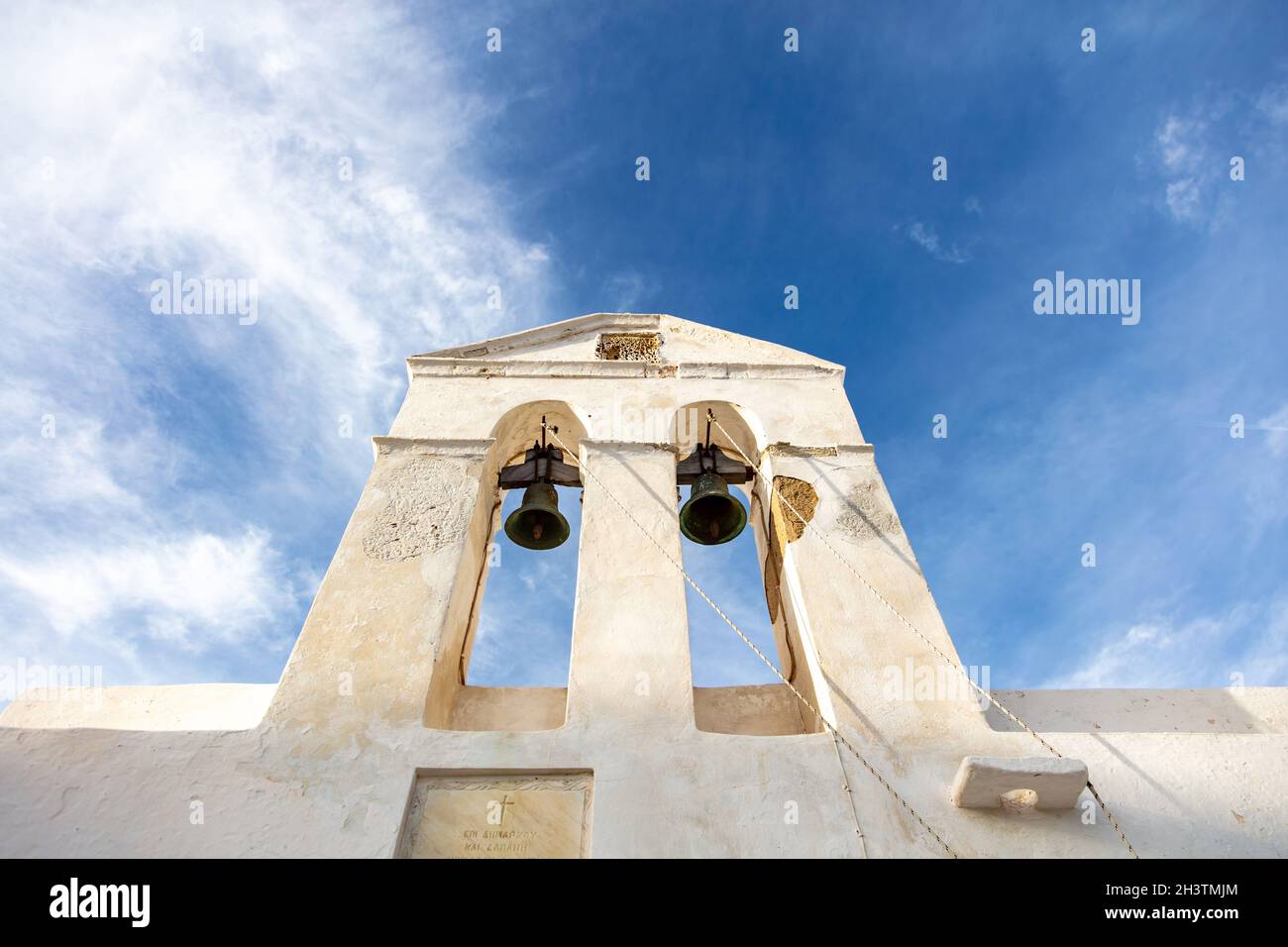 Grecia, Cicladi. Serifos isola, vecchia chiesa campanile vista angolo basso. Tradizionale cappella delle Cicladi, pareti dipinte di bianco, sfondo cielo blu nuvoloso. Foto Stock