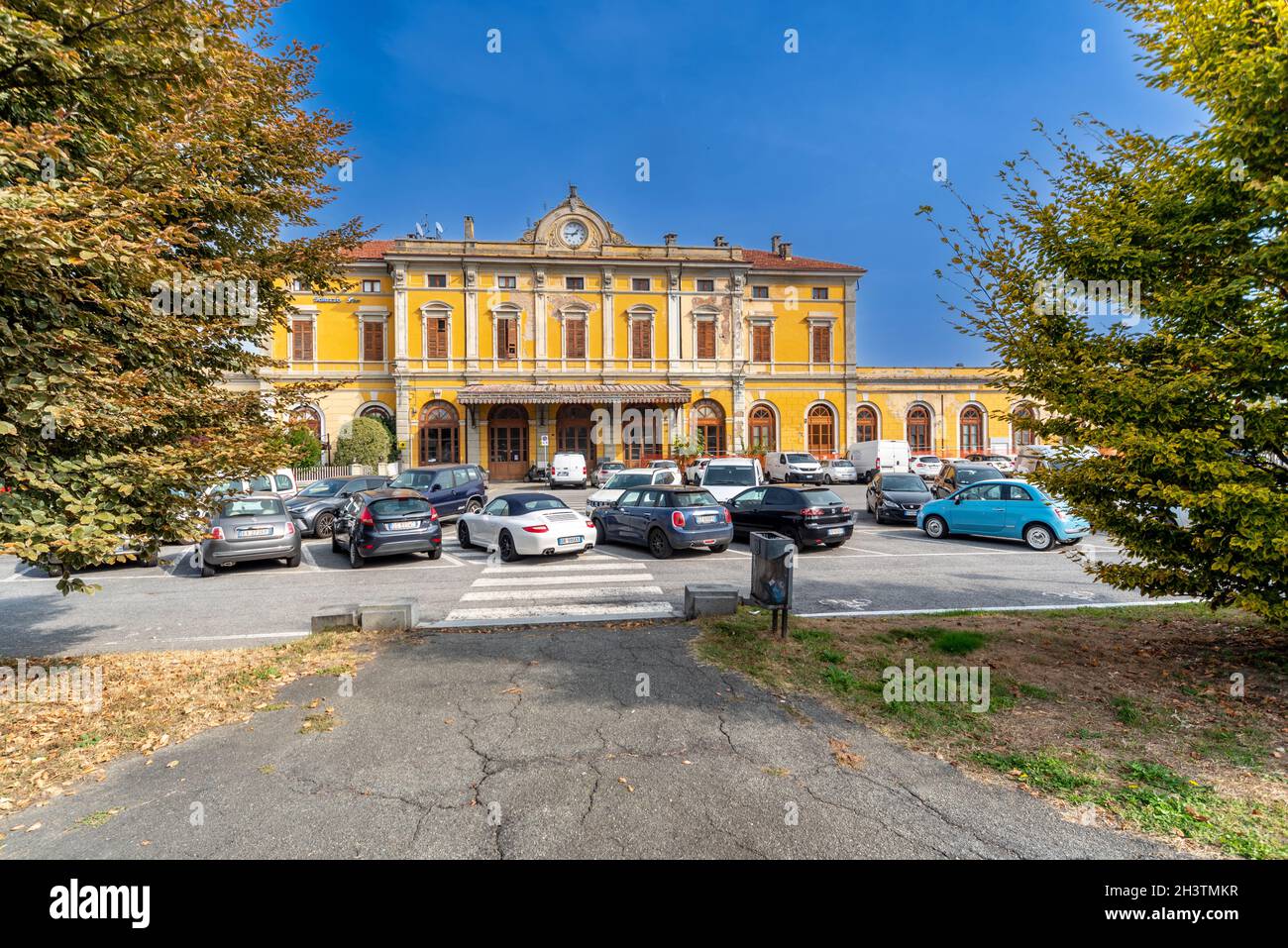 Saluzzo, Cuneo, Italia - 19 ottobre 2021: Vecchia stazione ferroviaria in corso Roma con alberi colorati in autunno Foto Stock
