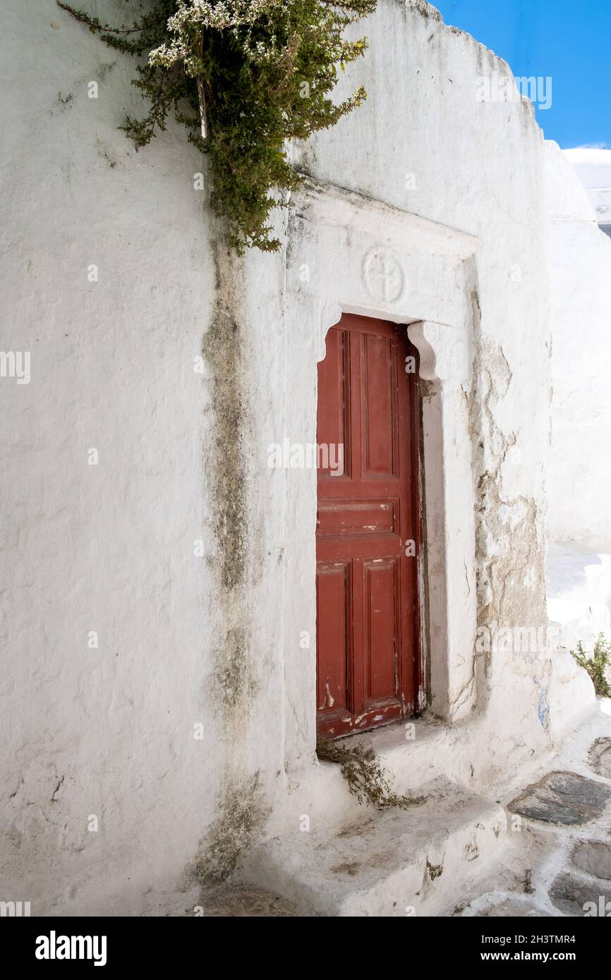 Grecia, Cicladi. Isola di Mykonos. Porta barbata in legno con cartello a croce, vecchia chiesa a Chora. Tradizionale cappella delle Cicladi, muro bianco, spazio, templ Foto Stock