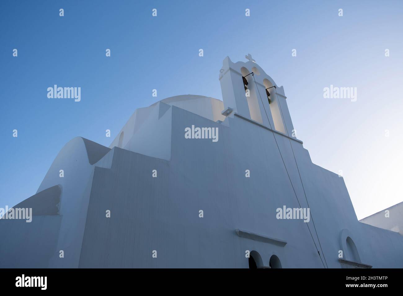 Grecia, Cicladi. Isola FOLEGANDROS, campanile della chiesa vecchia nella città di Chora. Tradizionale cappella delle Cicladi, pareti dipinte di bianco, cielo blu chiaro sfondo. Foto Stock