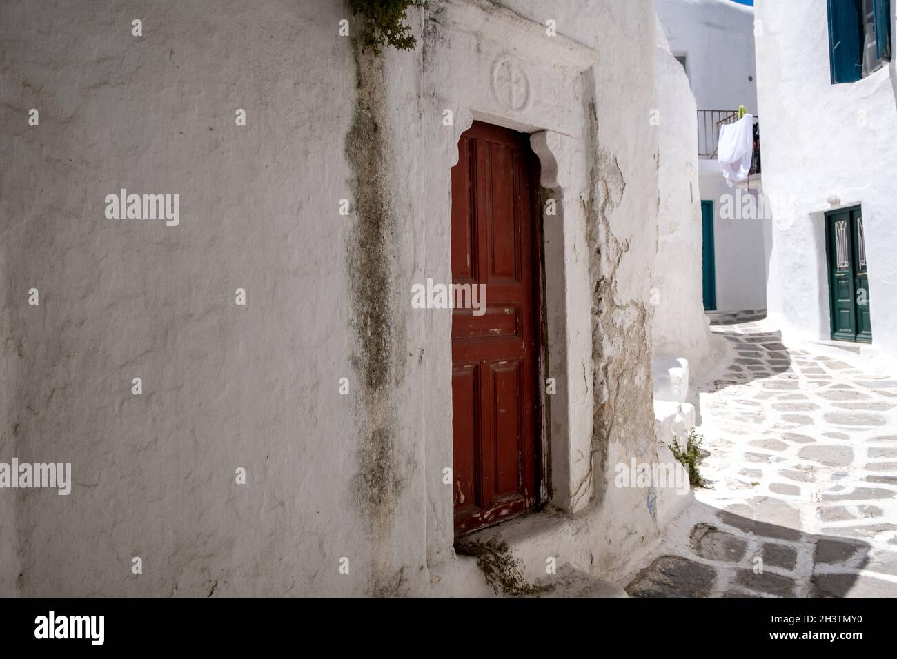 Grecia, Cicladi. Isola di Mykonos. Porta barbata in legno con cartello a croce, vecchia chiesa a Chora. Tradizionale cappella delle Cicladi, muro bianco, spazio, templ Foto Stock