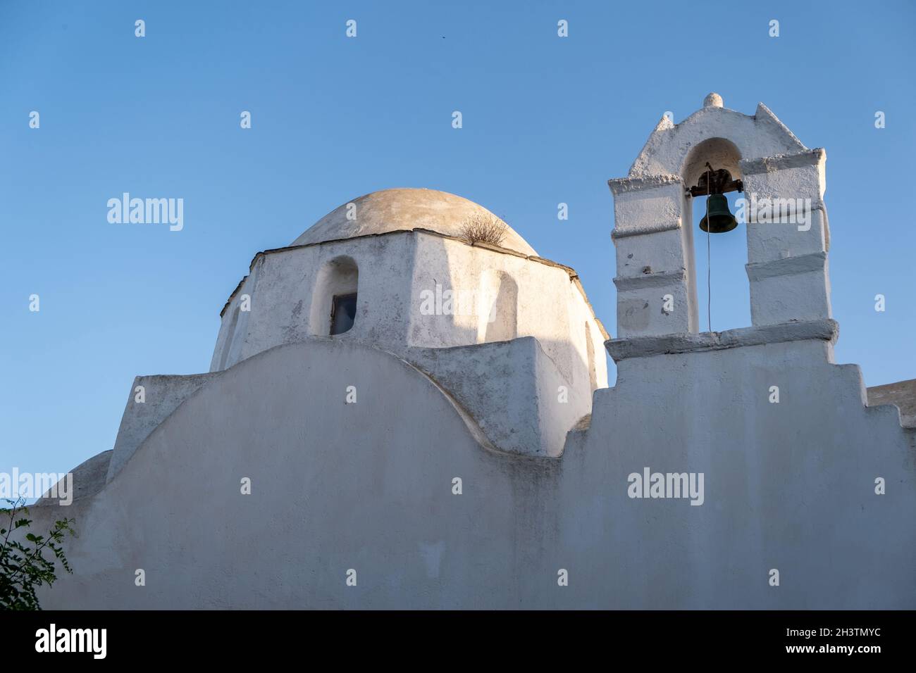 FOLEGANDROS isola, vecchia chiesa cupola e campanile a Chora città. Grecia, Cicladi. Cappella di Agios Antonios, pareti bianche, cielo blu chiaro sfondo. Foto Stock