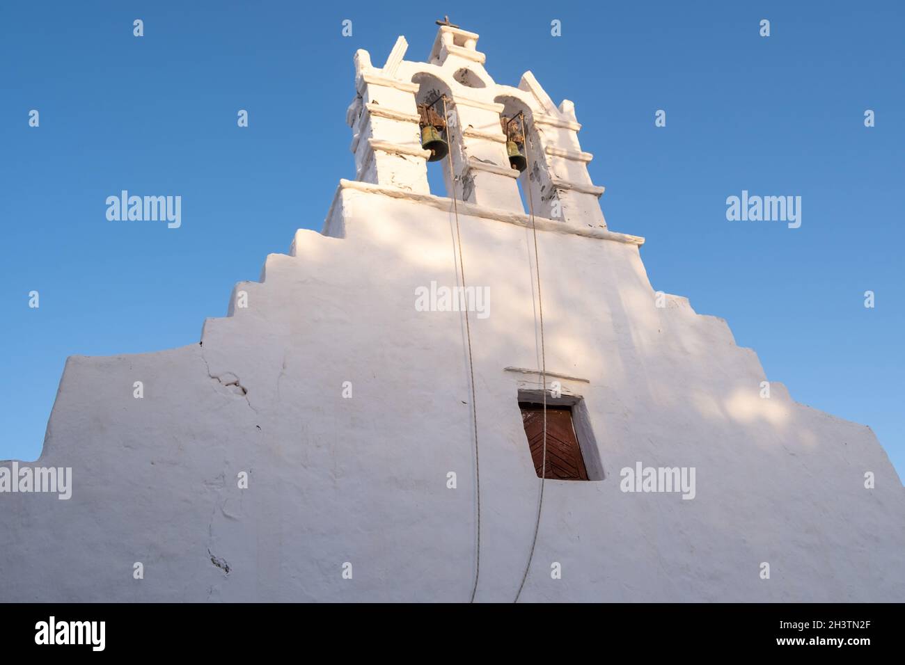 Grecia, Cicladi. Isola FOLEGANDROS, campanile della chiesa vecchia nella città di Chora. Tradizionale cappella delle Cicladi, pareti dipinte di bianco, cielo blu chiaro sfondo. Foto Stock