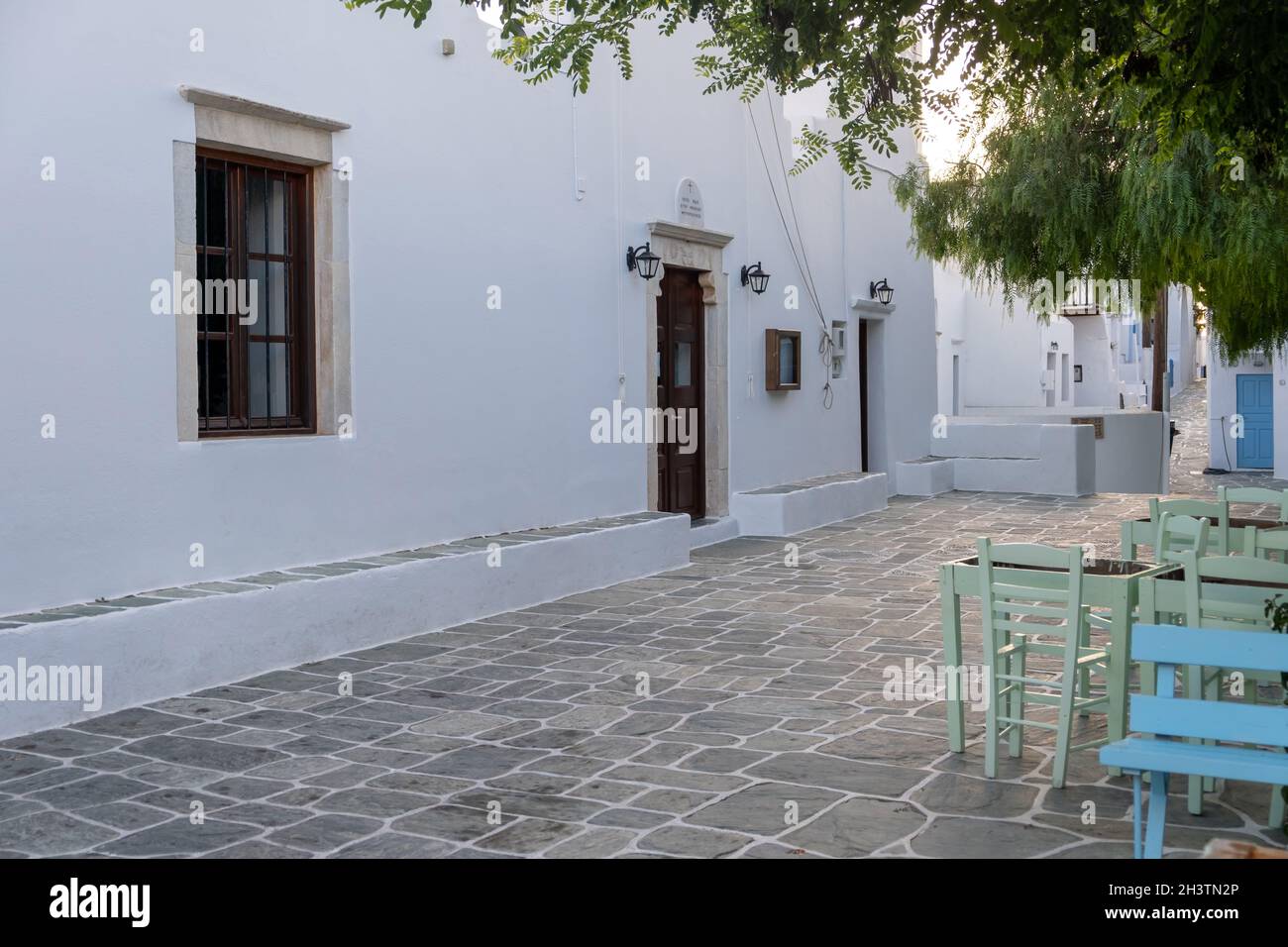 FOLEGANDROS isola, chiesa vecchia ingresso in piazza Chora città. Grecia, Cicladi. Cappella di Agios Antonios, pareti dipinte di bianco Foto Stock