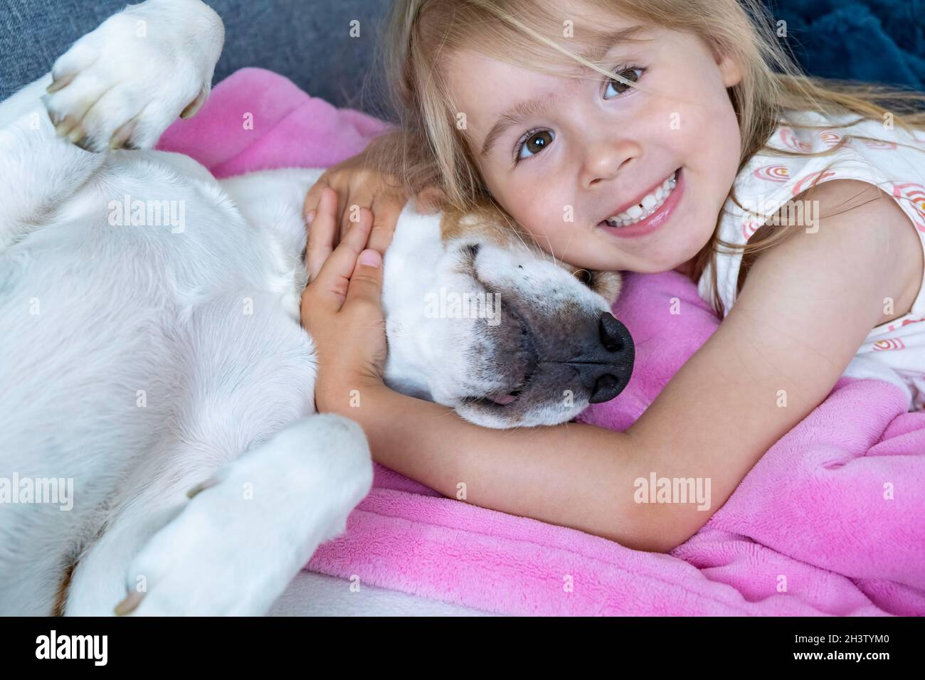 Happy Child coccolare un cane beagle migliore amico sul divano. Foto Stock