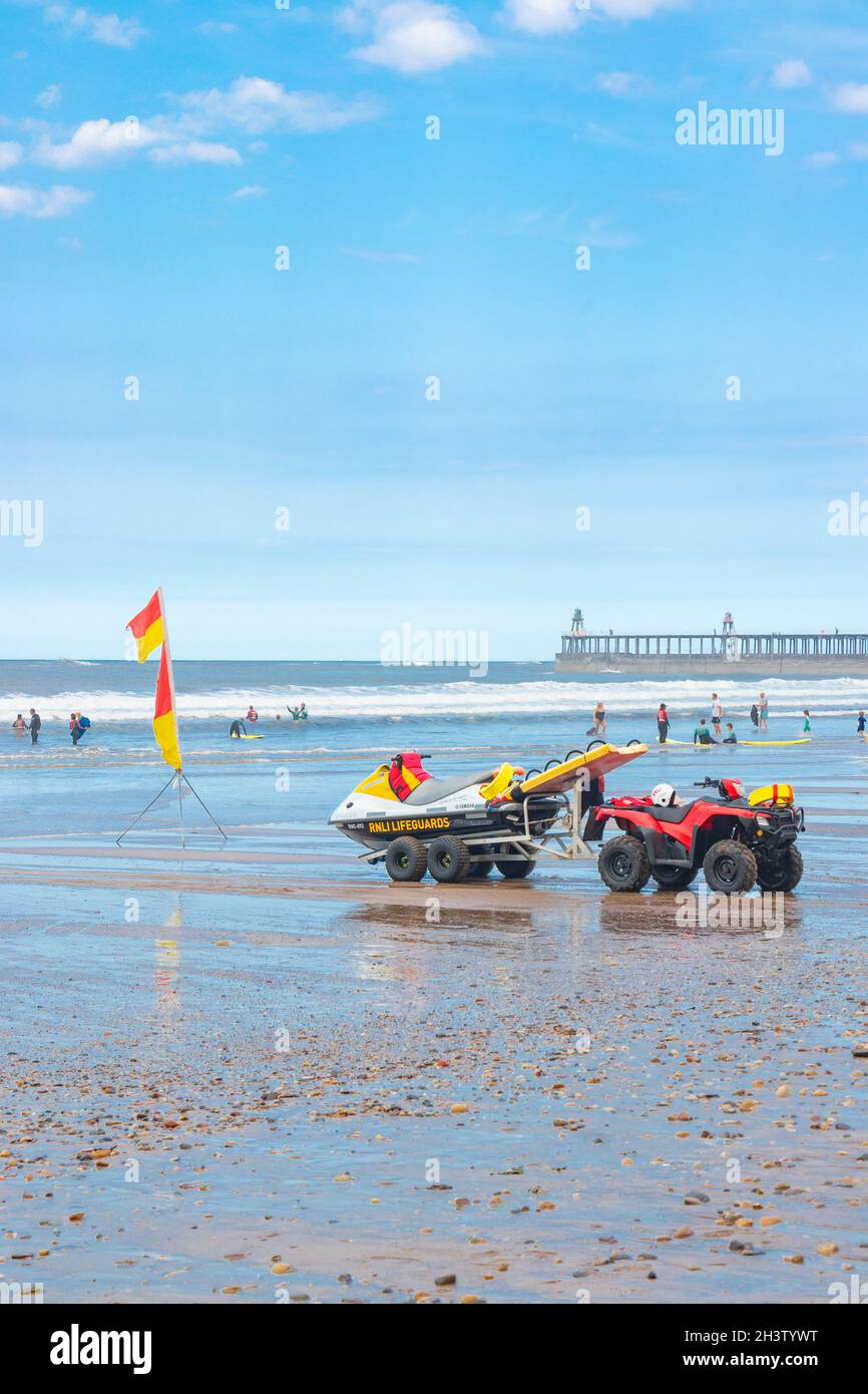 Bagnino RNLI ATV con moto d'acqua di soccorso sul rimorchio sulla spiaggia di Whitby nello Yorkshire Foto Stock