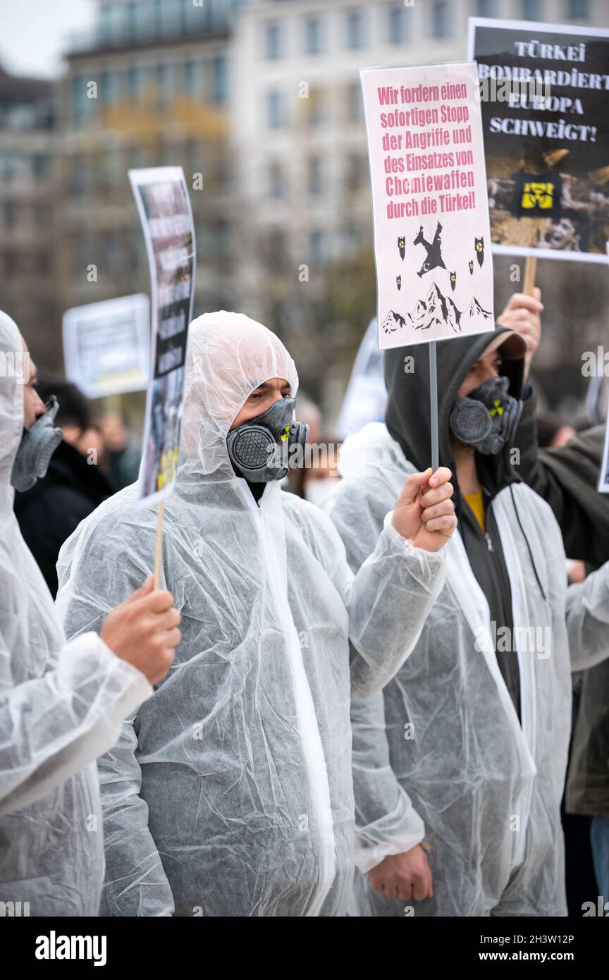 Amburgo, Germania. 30 Ott 2021. I manifestanti in tute bianche di  protezione mostrano cartelli che, tra le altre cose, leggono "chiediamo un  arresto immediato degli attacchi della Turchia e l'uso di armi