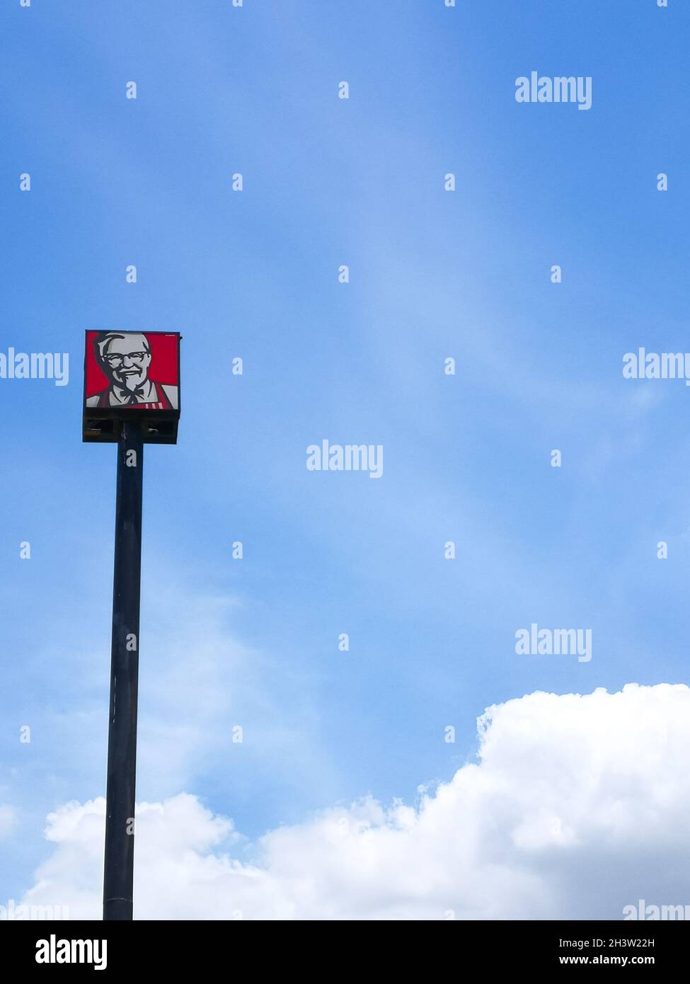 Bangkok, Thailandia – 23 giugno 2021 : logo KFC su palo in blu cielo sfondo. Il Kentucky Fried Chicken è una catena di ristoranti fast food globale sellin Foto Stock