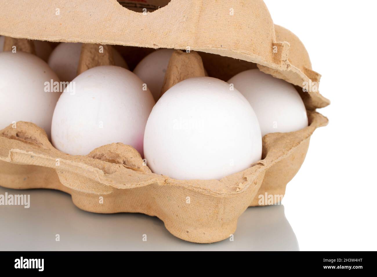 Diverse uova di pollo organico in una scatola di carta, primo piano, isolato su bianco. Foto Stock