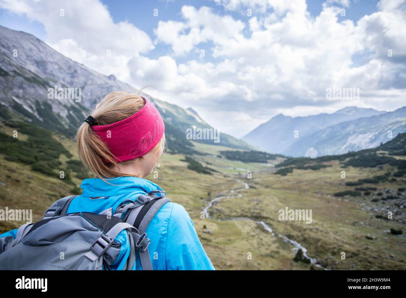 Donna bionda alpinista con zaino è godendo della vista Foto Stock
