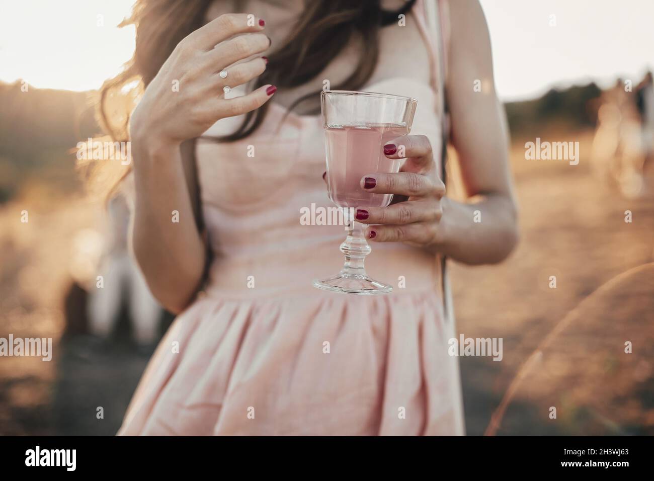 Crop femmina con un bicchiere di succo rosa Foto Stock