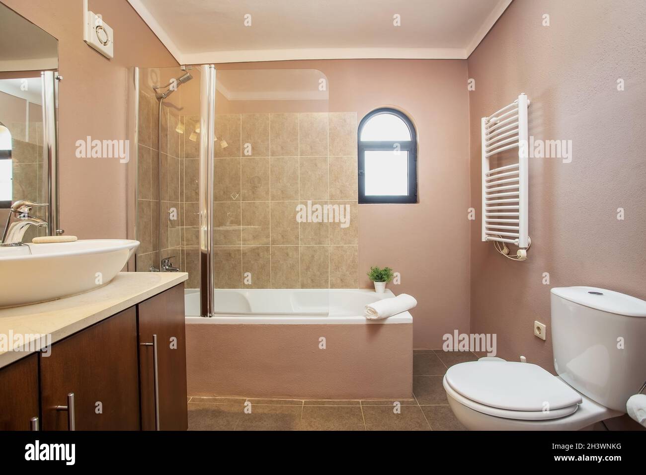 Bagno moderno e tradizionale, con servizi igienici, vasca da bagno, piastrelle in ceramica tutto intorno. Asciugando, asciugamano, Foto Stock