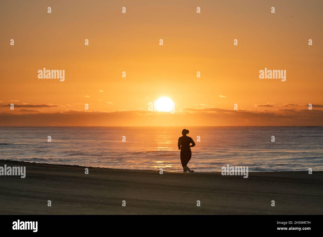 Alba a Meloeras, Gran Canaria con jogger sulla spiaggia Foto Stock