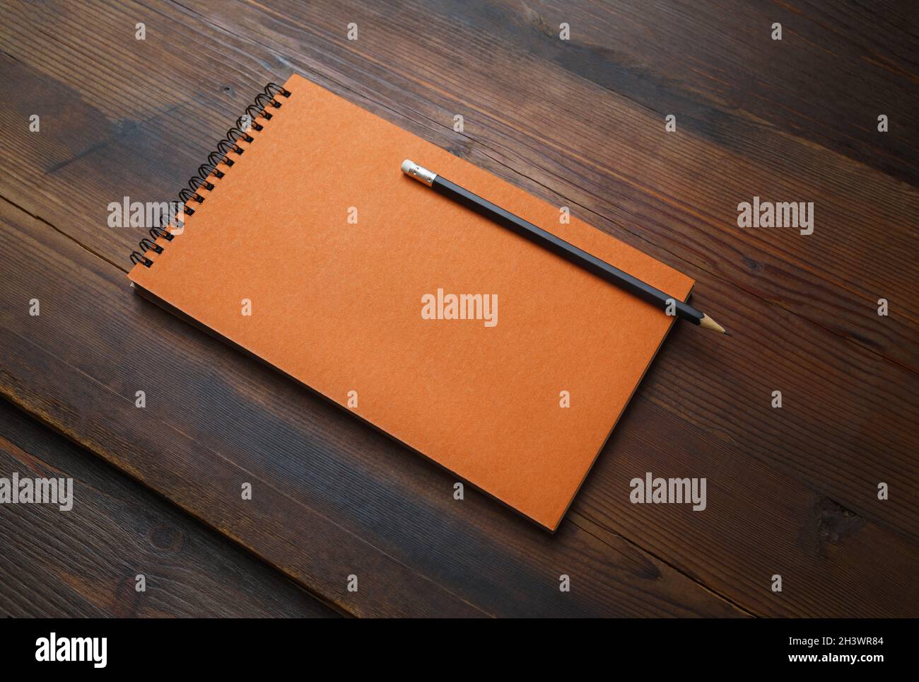 Blocco note arancione, matita Foto Stock