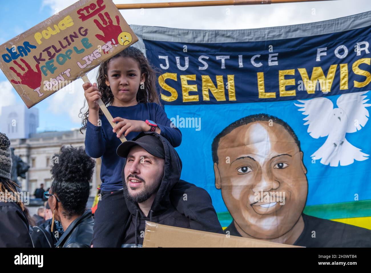 Londra, Regno Unito. 30 ottobre 2021. Manifestanti davanti alla bandiera per Seni Lewis, ucciso dalla polizia. La processione annuale del ricordo della Campagna delle famiglie unite e degli amici (UFFC) si sposa lentamente in silenzio da Trafalgar Square a Downing St per un forte raduno con i relatori delle famiglie interessate che chiedono giustizia per i parenti uccisi dalla polizia e in detenzione penale, mentale e migratoria. Dicono "non c'è giustizia, non c'è pace”. Peter Marshall/Alamy Live News Foto Stock
